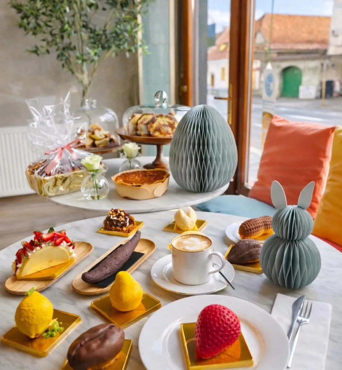 Masa de lângă fereastra magazinului nostru, cu deserturi, cafea și priveliștea străzii din Brașov